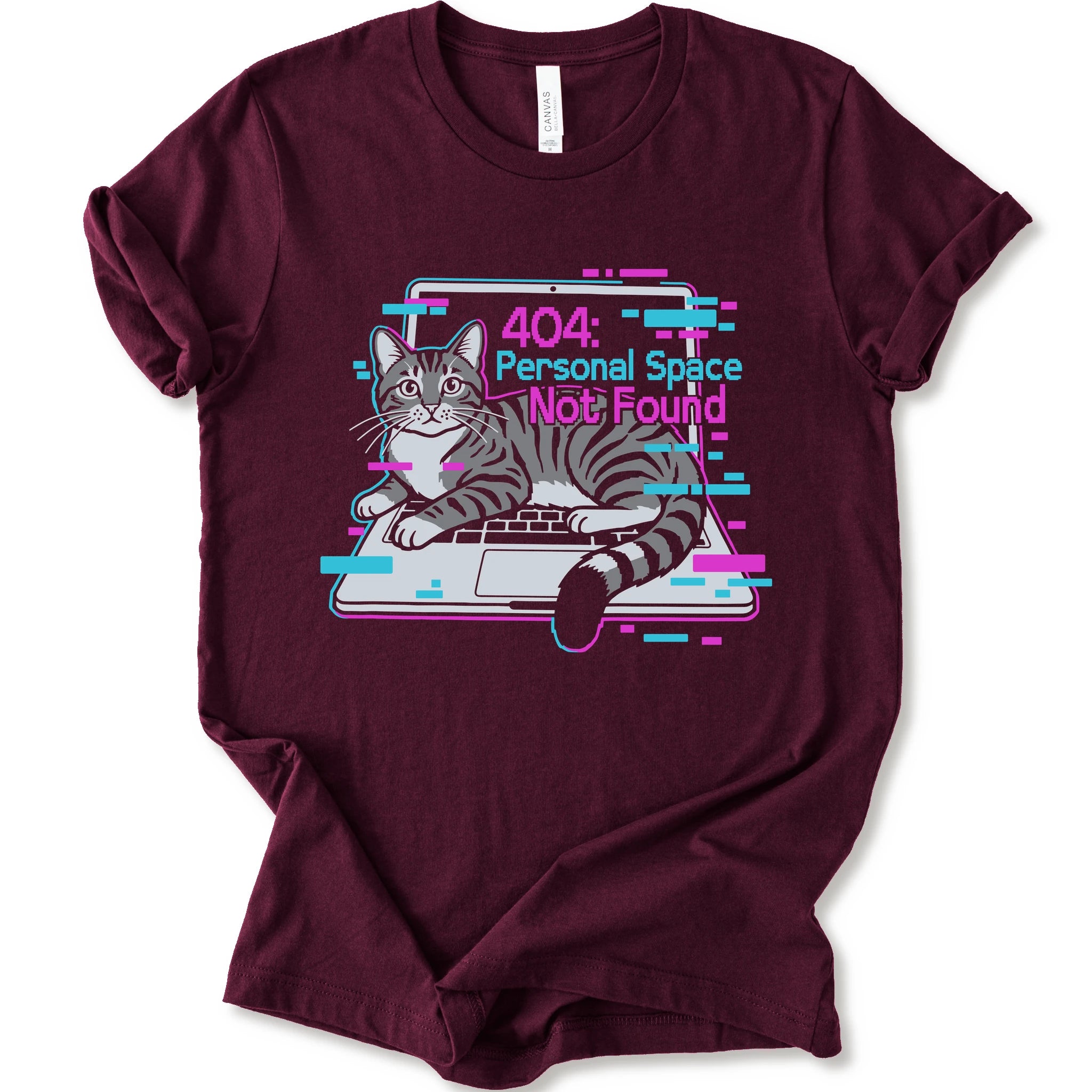 A maroon short-sleeve crewneck t-shirt with a graphic print of a gray tabby cat sitting in front of a laptop displaying a '404: Personal Space Not Found' error message in pink and cyan text.