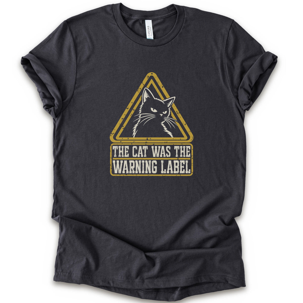 A dark grey short-sleeve crewneck t-shirt with a distressed yellow and white graphic on the front showing a cat inside a warning triangle and the text 'THE CAT WAS THE WARNING LABEL'.