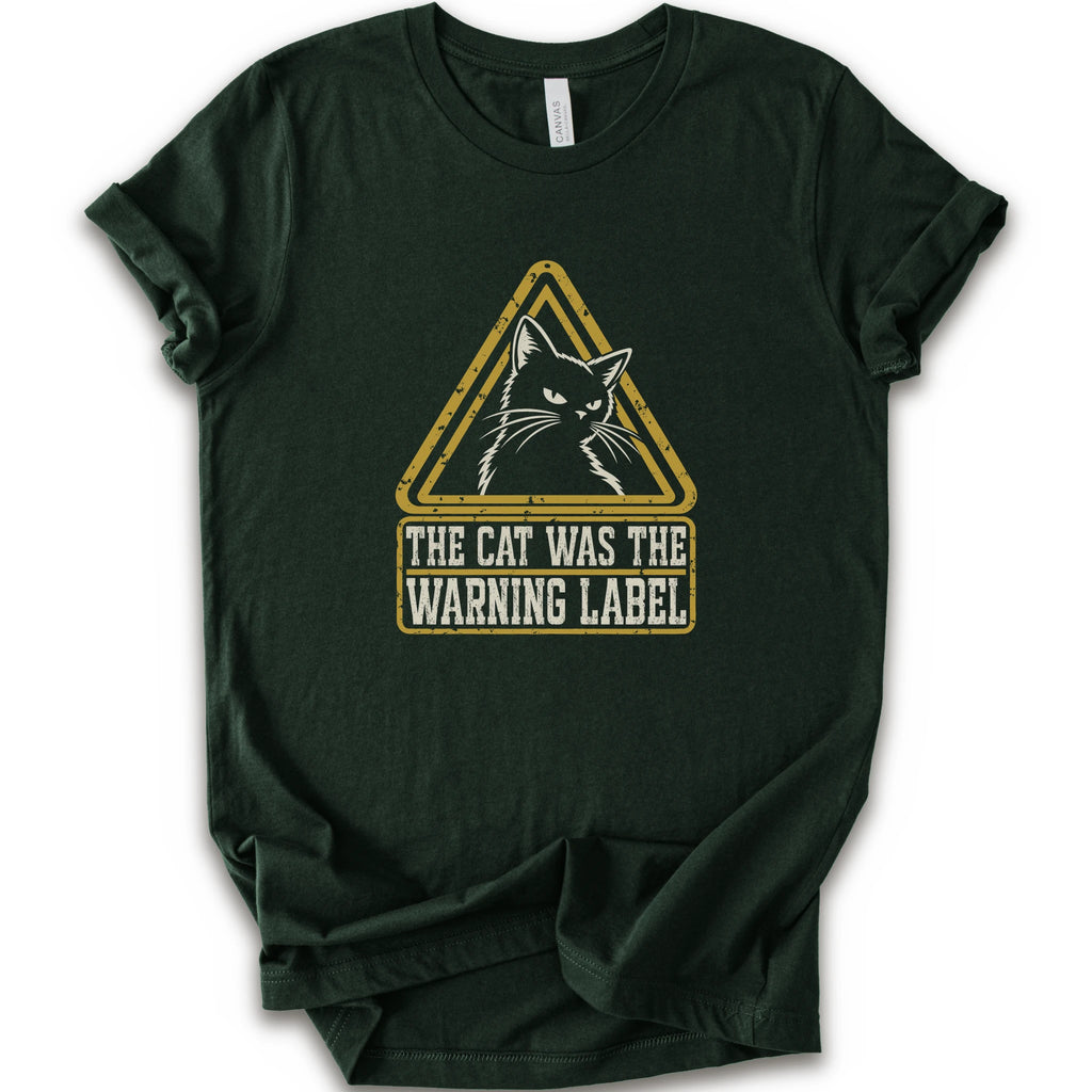 A forest short-sleeve crewneck t-shirt with a distressed yellow and white graphic on the front showing a cat inside a warning triangle and the text 'THE CAT WAS THE WARNING LABEL'.