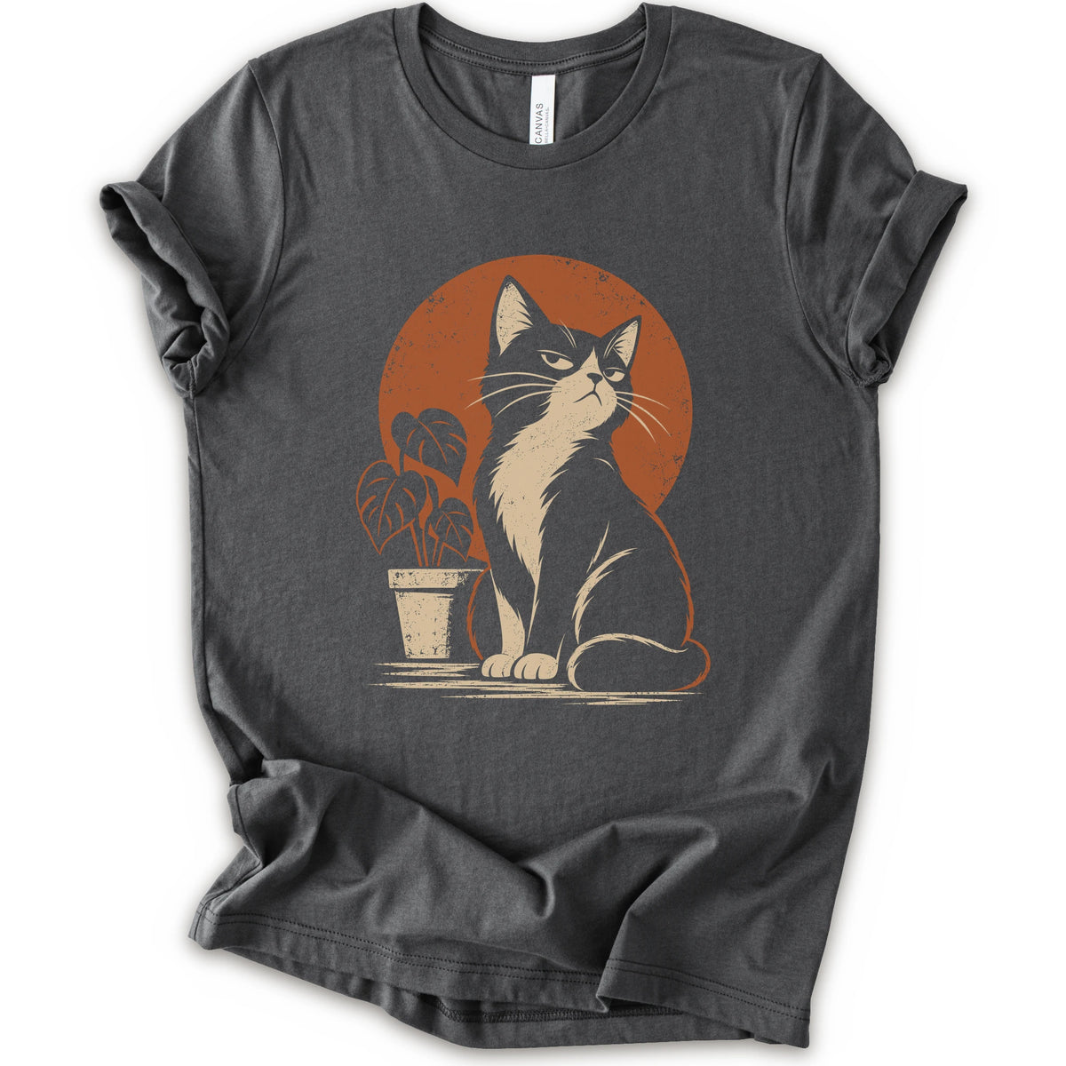 An asphalt short-sleeve crewneck t-shirt with a retro-style graphic of a black and white cat sitting in front of an orange circular sun, next to a potted plant.