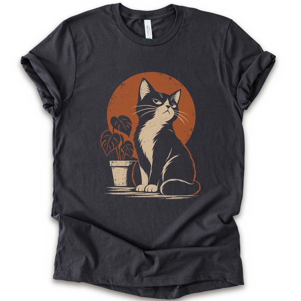 A dark grey short-sleeve crewneck t-shirt with a retro-style graphic of a black and white cat sitting in front of an orange circular sun, next to a potted plant.