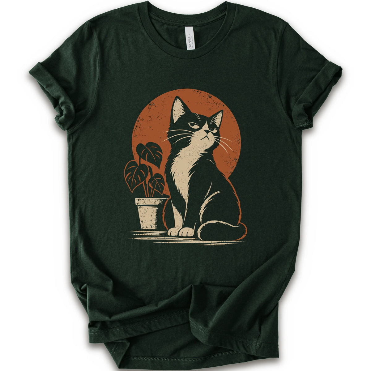 A forest short-sleeve crewneck t-shirt with a retro-style graphic of a black and white cat sitting in front of an orange circular sun, next to a potted plant.