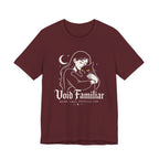 A maroon short-sleeve crewneck t-shirt featuring a graphic with Woman hugging a black cat beneath a crescent moon with “Void Familiar” and “Weird. Tired. Perfectly Fine.” text