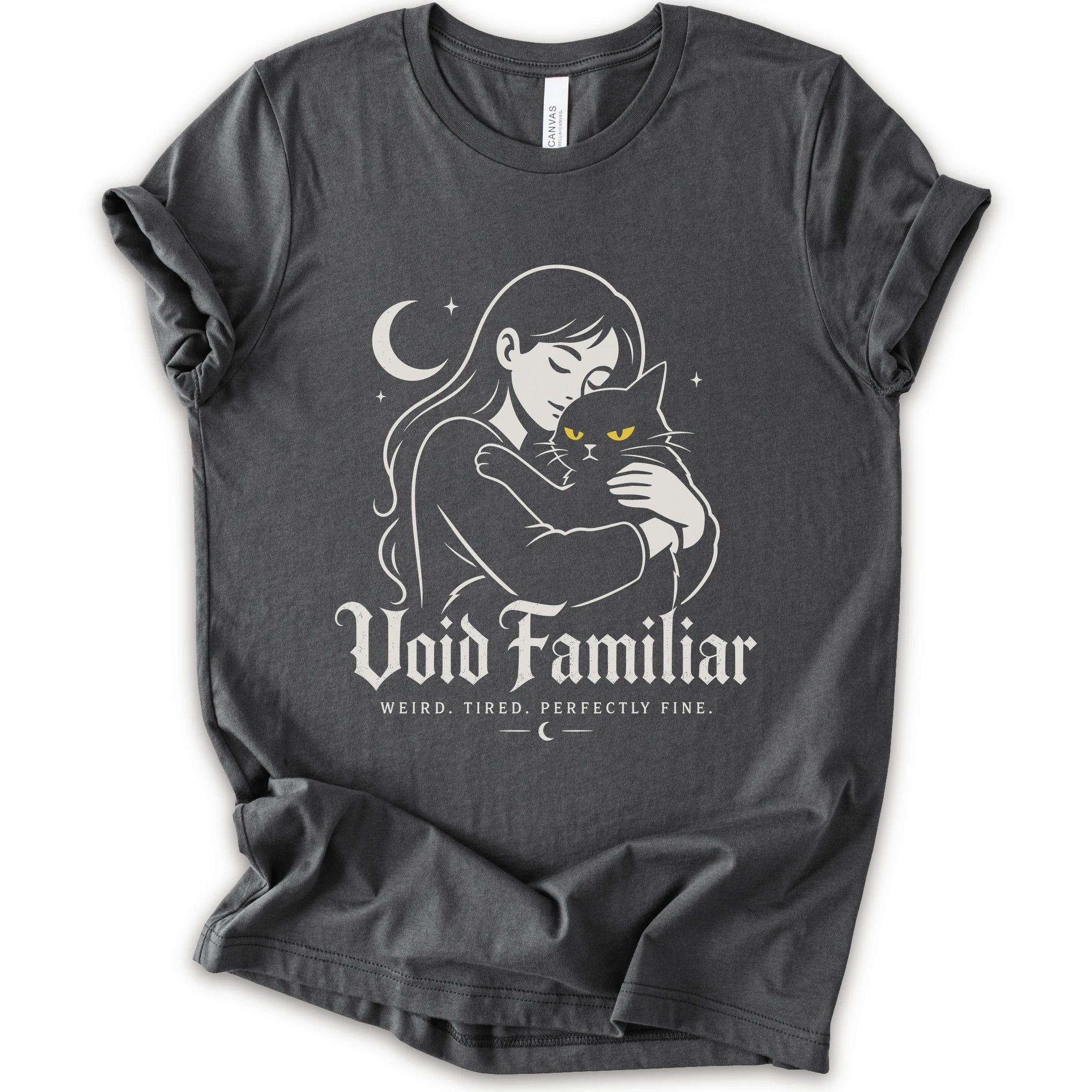 Asphalt graphic t-shirt with a woman hugging a black cat beneath a crescent moon with “Void Familiar” and “Weird. Tired. Perfectly Fine.” text