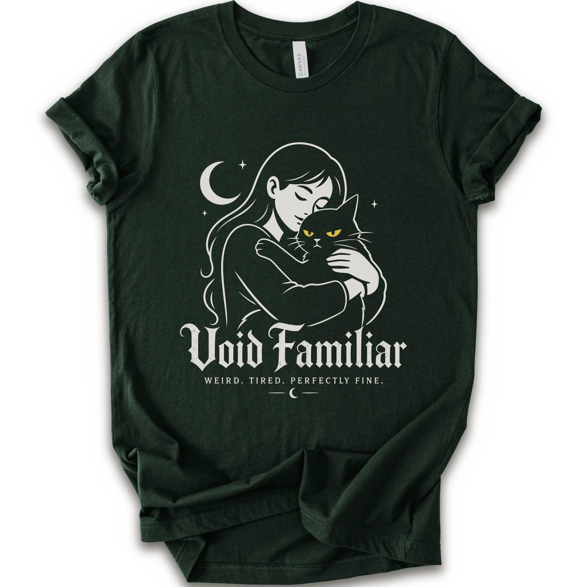 Forest graphic t-shirt with a woman hugging a black cat beneath a crescent moon with “Void Familiar” and “Weird. Tired. Perfectly Fine.” text