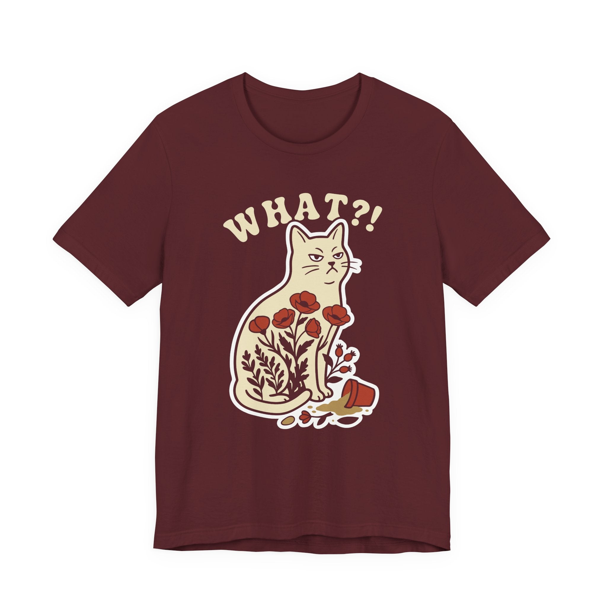 A maroon short-sleeve t-shirt with a graphic of a white cat sitting among red flowers, with the text 'WHAT?!' above it