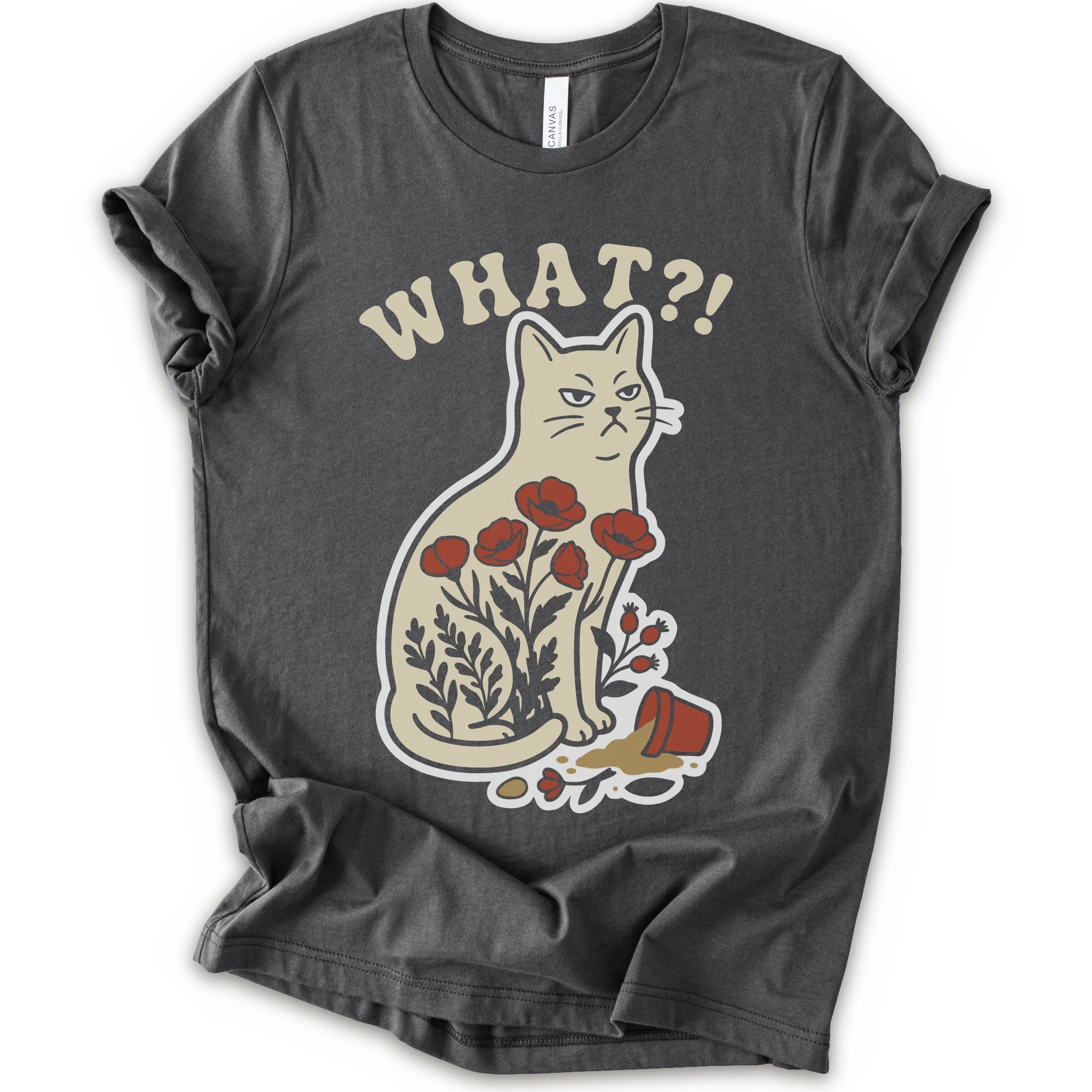 Asphalt graphic t-shirt with “WHAT?!” text above an unimpressed cream cat with red flowers beside a knocked-over plant pot