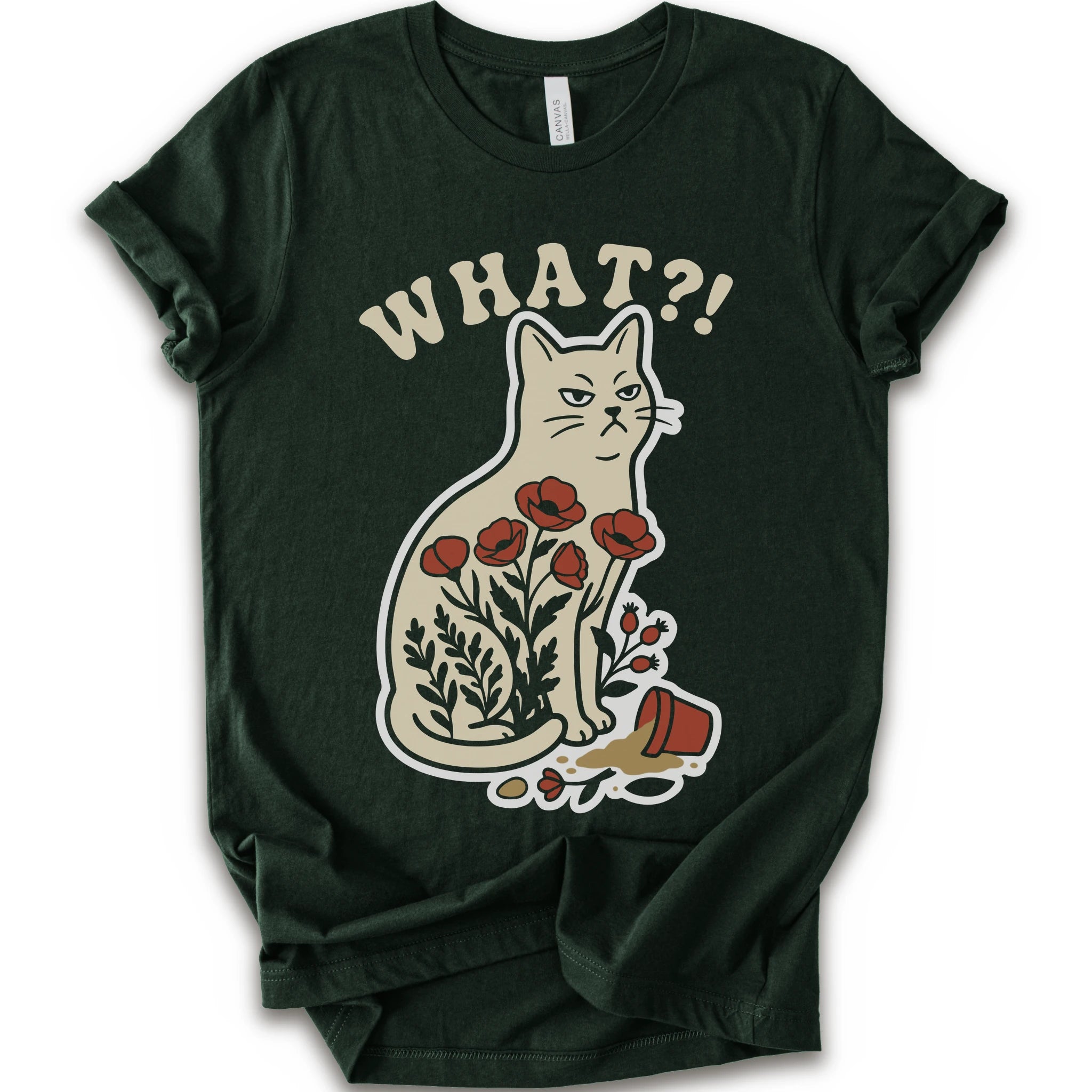 Forest graphic t-shirt with “WHAT?!” text above an unimpressed cream cat with red flowers beside a knocked-over plant pot