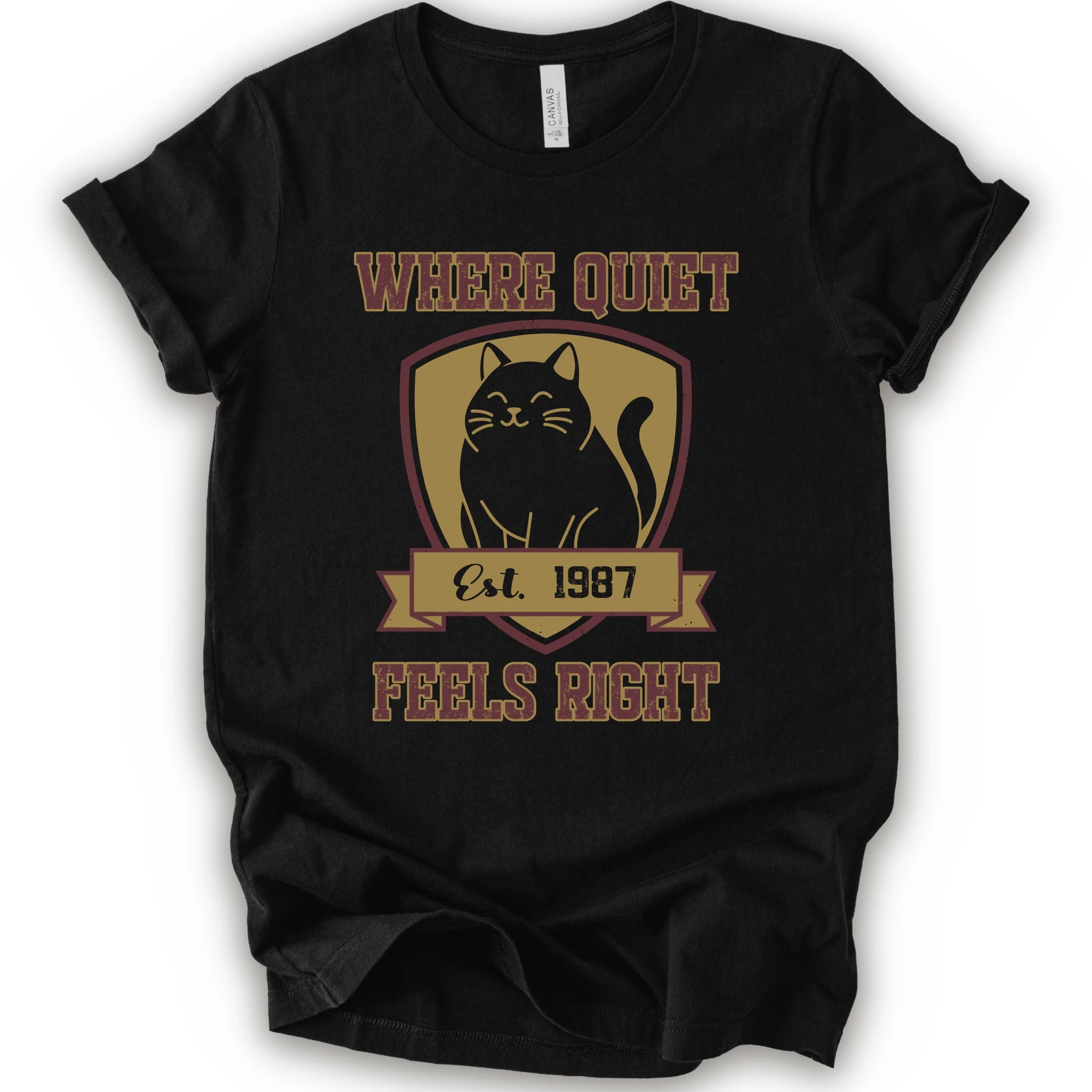A black short-sleeve t-shirt with a vintage-style graphic on the front featuring a black cat inside a gold shield and the text 'WHERE QUIET FEELS RIGHT Est. 1987'.
