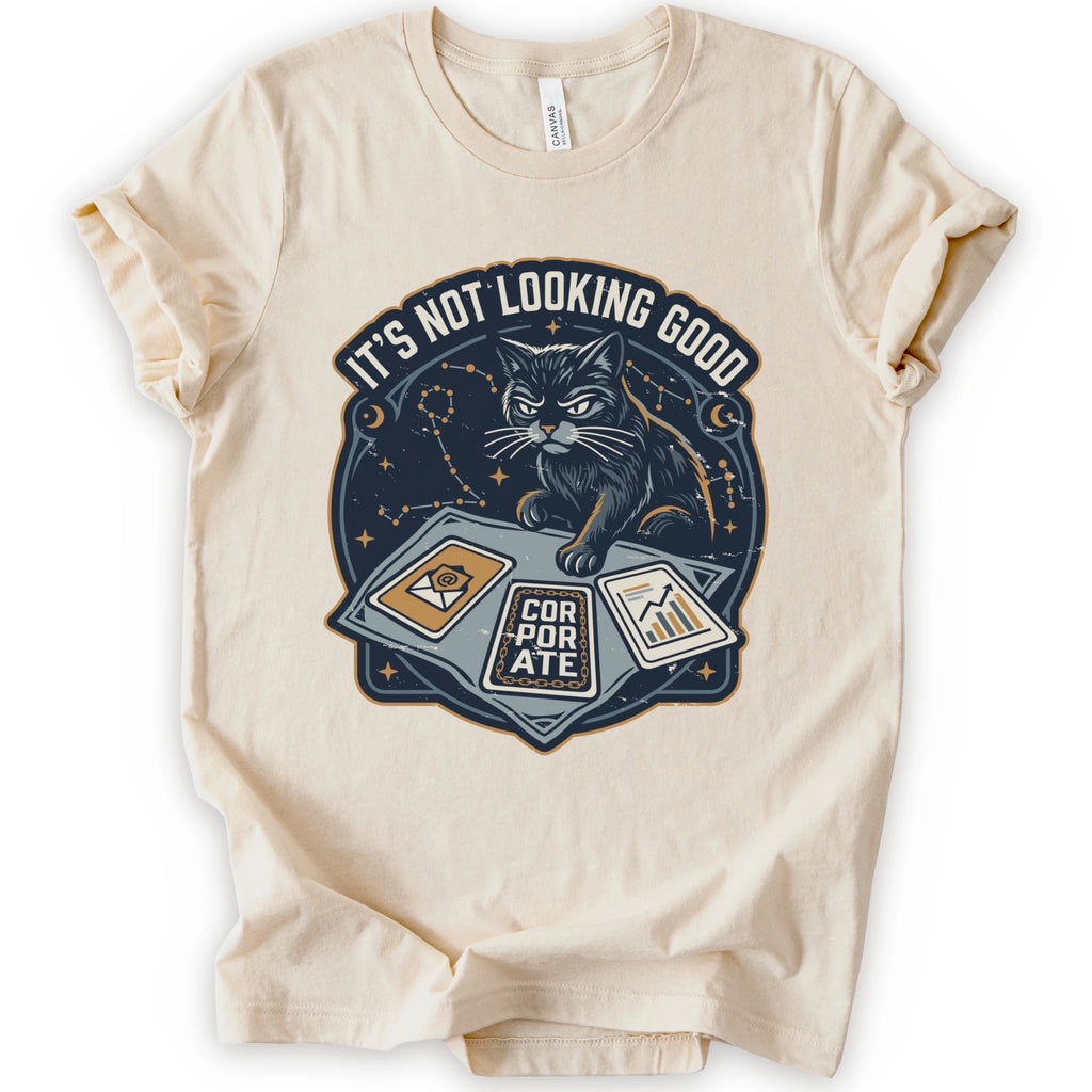 A natural short-sleeve t-shirt with a graphic print of a black cat sitting on a laptop with the text 'IT'S NOT LOOKING GOOD' and 'CORPORATE'.