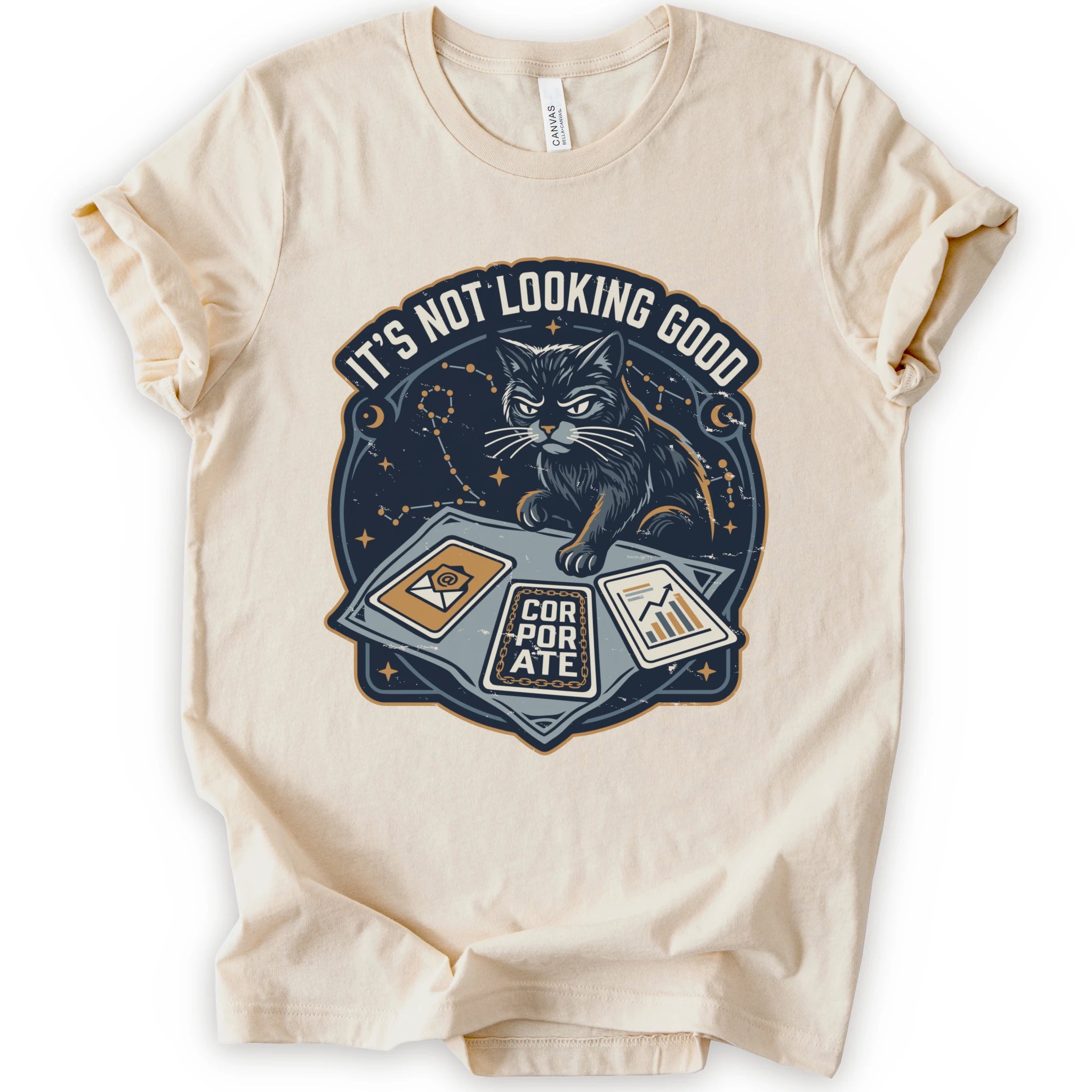 A natural short-sleeve t-shirt with a graphic print of a black cat sitting on a laptop with the text 'IT'S NOT LOOKING GOOD' and 'CORPORATE'.