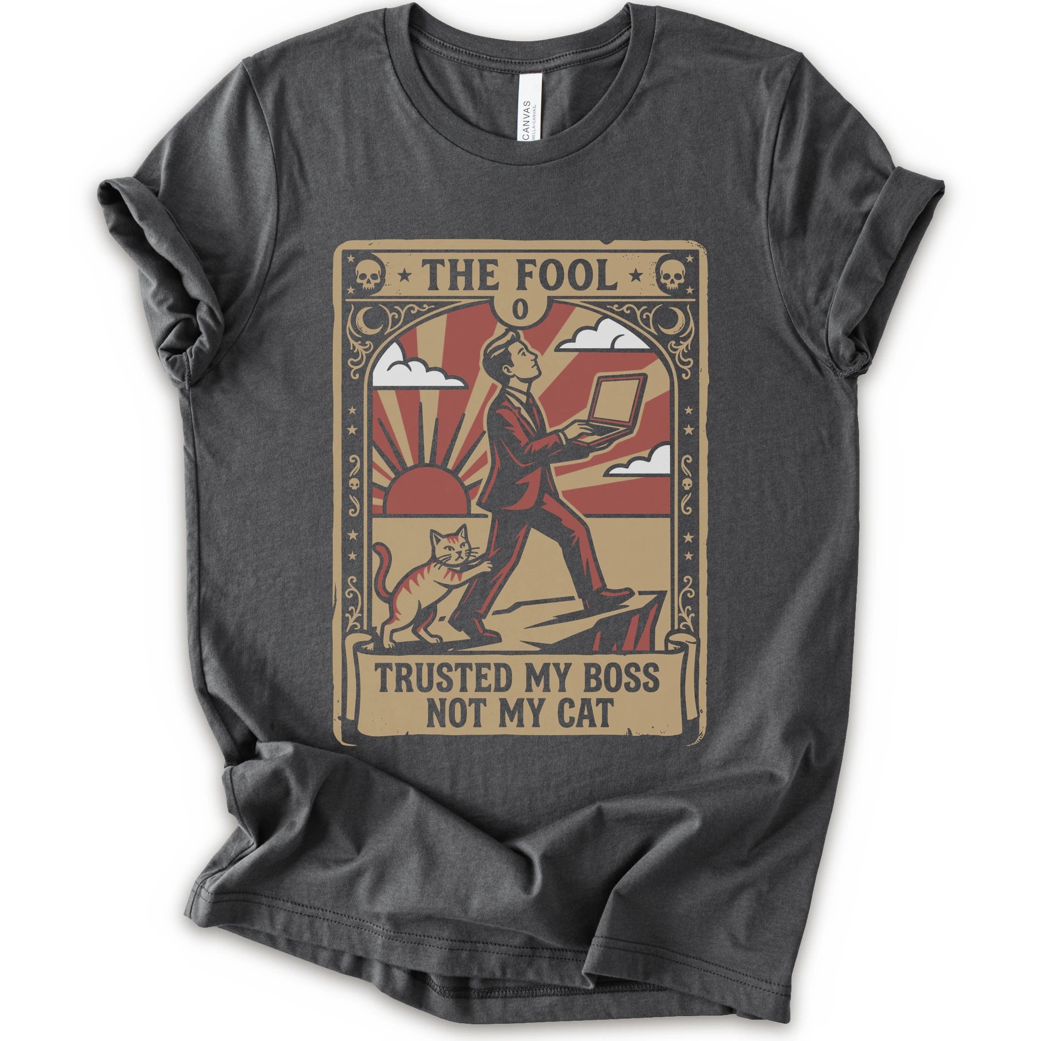 A asphalt short-sleeve crewneck t-shirt with a vintage-style graphic print on the front. The graphic is styled like an old tarot card, featuring a man in a suit walking on a cliff while a cat watches, with the text 'THE FOOL' at the top and 'TRUSTED MY BOSS NOT MY CAT' at the bottom.