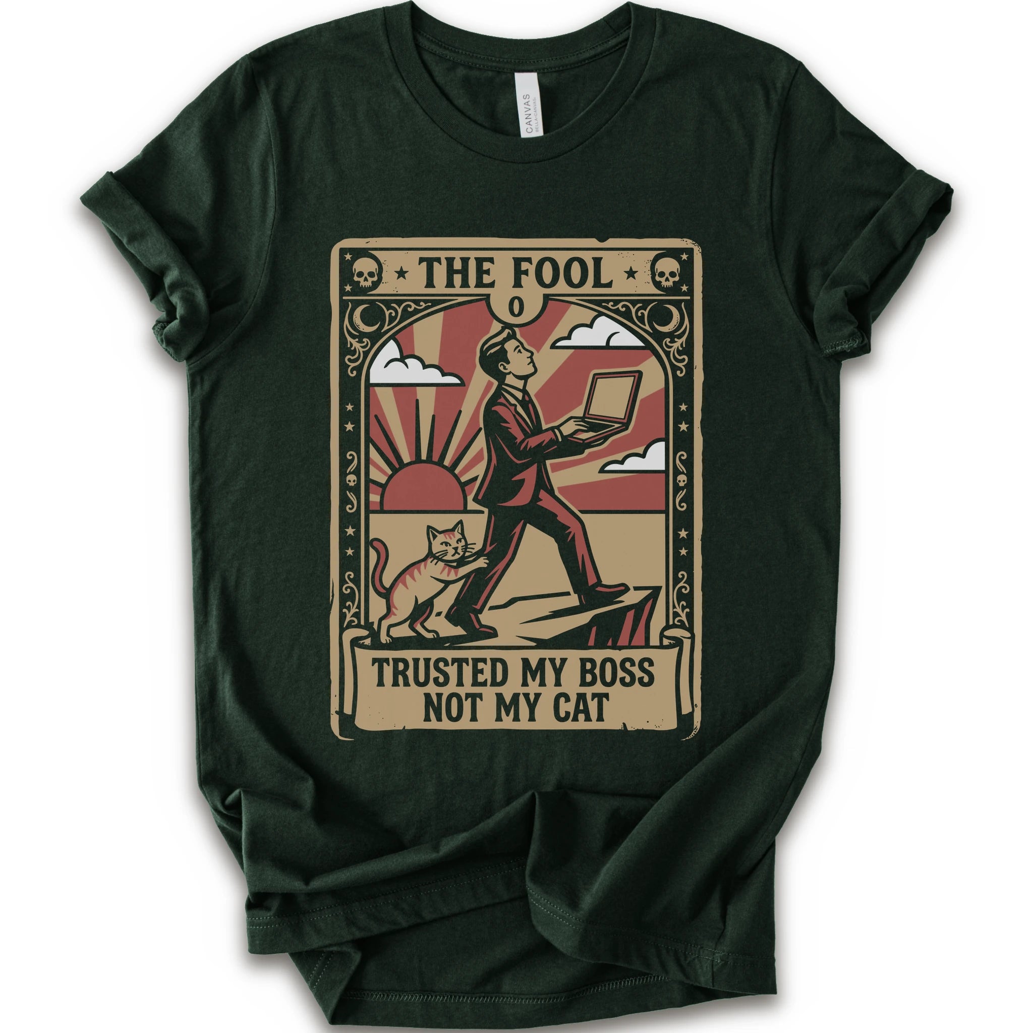 A forest short-sleeve crewneck t-shirt with a vintage-style graphic print on the front. The graphic is styled like an old tarot card, featuring a man in a suit walking on a cliff while a cat watches, with the text 'THE FOOL' at the top and 'TRUSTED MY BOSS NOT MY CAT' at the bottom.