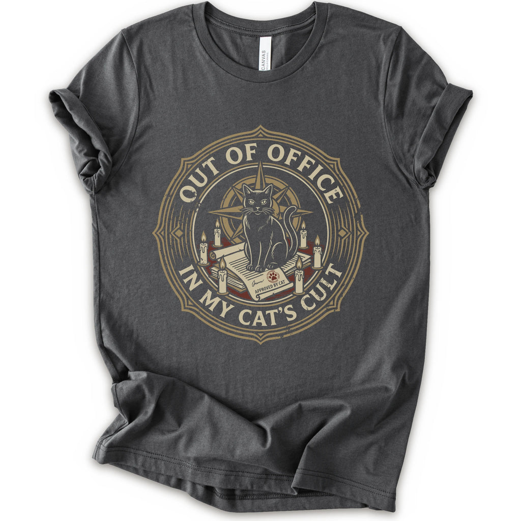 A asphalt short-sleeve crewneck t-shirt with a circular graphic on the chest. The graphic features a black cat sitting on an open book surrounded by candles, with the text 'OUT OF OFFICE' and 'IN MY CAT'S CULT' in a vintage serif font.
