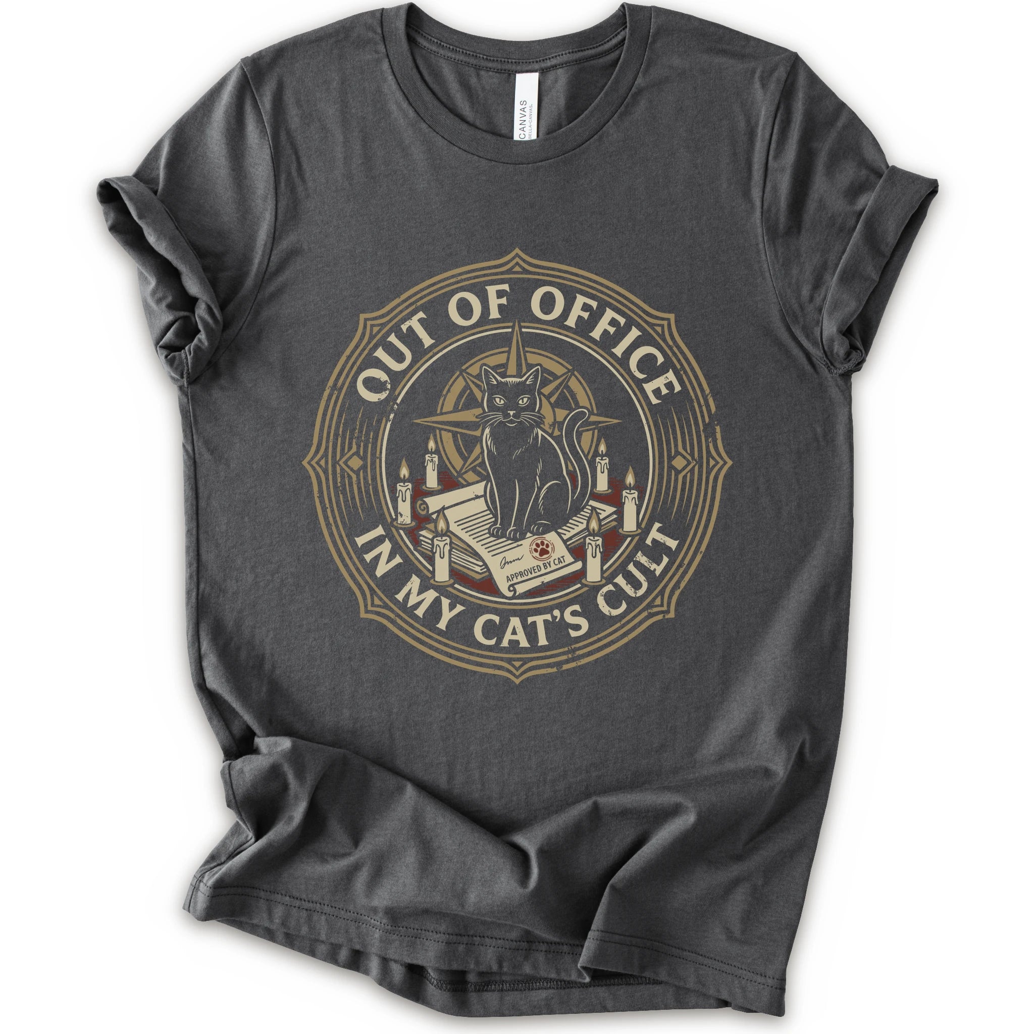 A asphalt short-sleeve crewneck t-shirt with a circular graphic on the chest. The graphic features a black cat sitting on an open book surrounded by candles, with the text 'OUT OF OFFICE' and 'IN MY CAT'S CULT' in a vintage serif font.