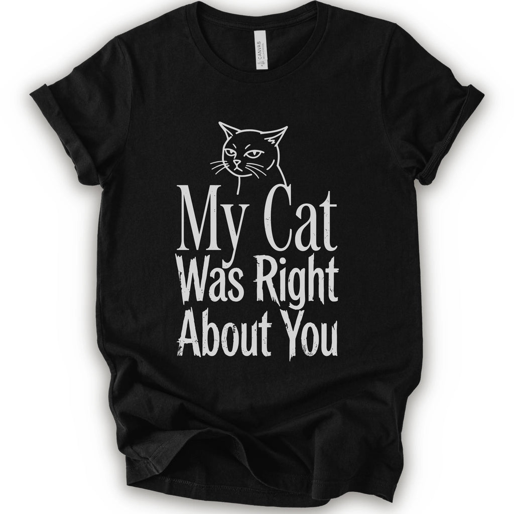 A black short-sleeve crewneck T-shirt with a cat rendered in white outline sits above the text “My Cat Was Right About You,” arranged in oversized mixed serif and distressed lettering.