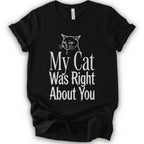 A black short-sleeve crewneck T-shirt with a cat rendered in white outline sits above the text “My Cat Was Right About You,” arranged in oversized mixed serif and distressed lettering.