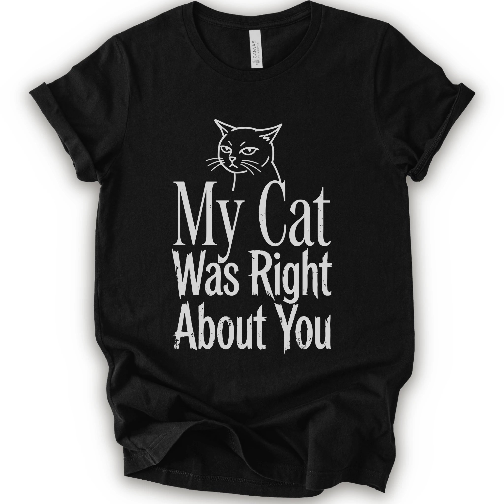 A black short-sleeve crewneck T-shirt with a cat rendered in white outline sits above the text “My Cat Was Right About You,” arranged in oversized mixed serif and distressed lettering.