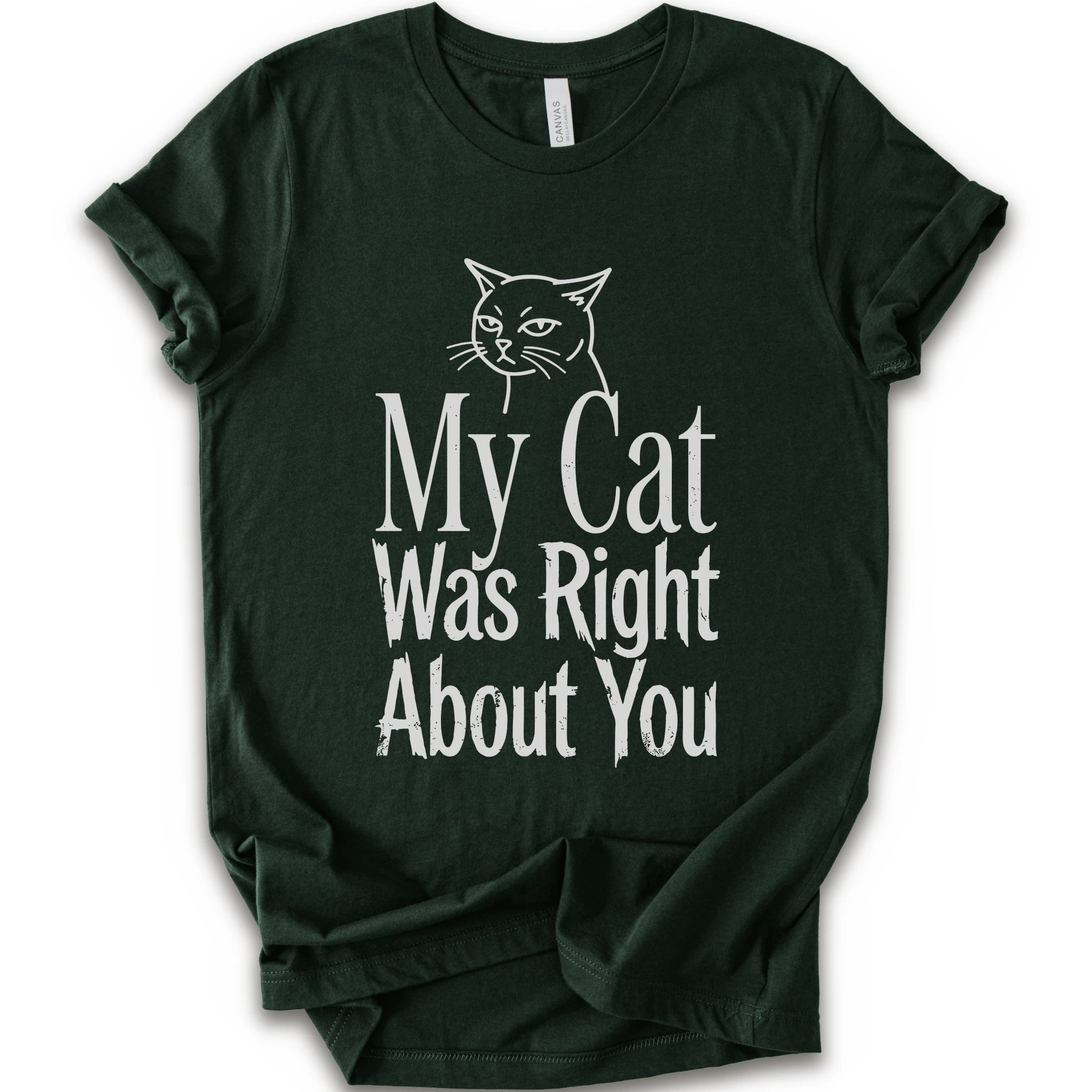 A forest short-sleeve crewneck T-shirt with a cat rendered in white outline sits above the text “My Cat Was Right About You,” arranged in oversized mixed serif and distressed lettering.