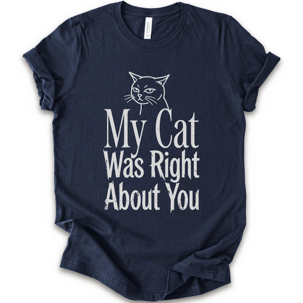 A navy short-sleeve crewneck T-shirt with a cat rendered in white outline sits above the text “My Cat Was Right About You,” arranged in oversized mixed serif and distressed lettering.