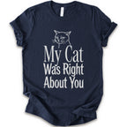 A navy short-sleeve crewneck T-shirt with a cat rendered in white outline sits above the text “My Cat Was Right About You,” arranged in oversized mixed serif and distressed lettering.