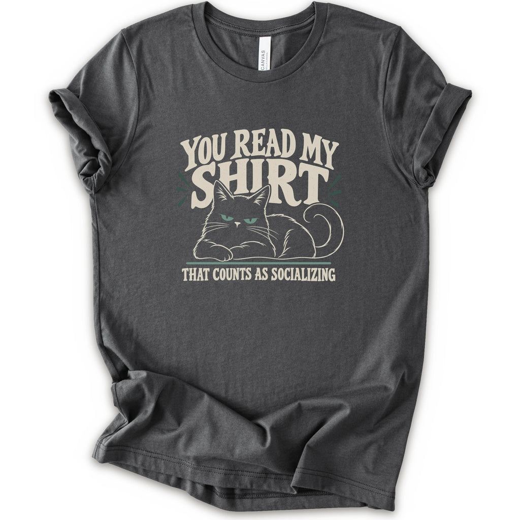 An asphalt short-sleeve crewneck t-shirt with a graphic print of a grumpy cat and the text 'YOU READ MY SHIRT THAT COUNTS AS SOCIALIZING' in cream and light green.