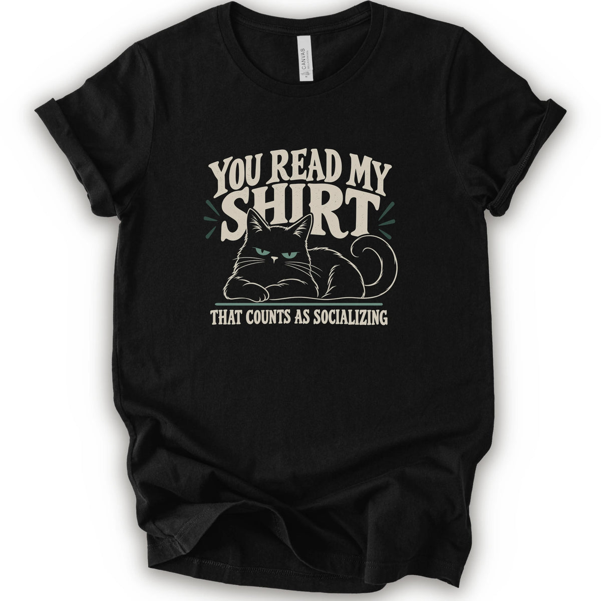A black short-sleeve crewneck t-shirt with a graphic print of a grumpy cat and the text 'YOU READ MY SHIRT THAT COUNTS AS SOCIALIZING' in cream and light green.