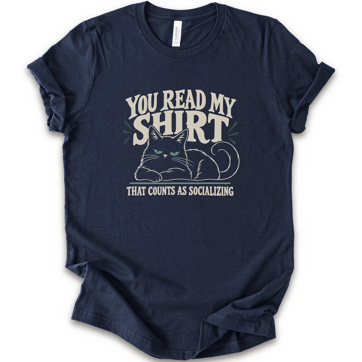 A navy short-sleeve crewneck t-shirt with a graphic print of a grumpy cat and the text 'YOU READ MY SHIRT THAT COUNTS AS SOCIALIZING' in cream and light green.